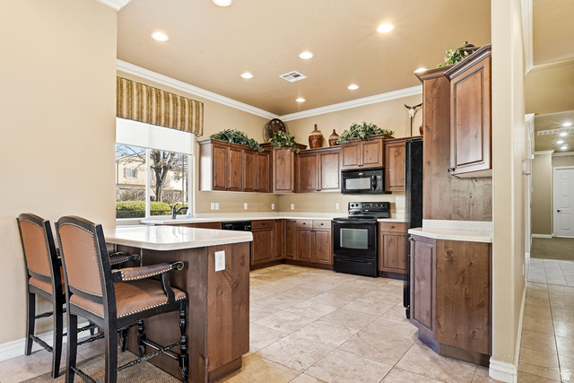 1177 Northfield Road, Unit 26 Cedar City, UT 84721 - Photo 36 of 45 Well-appointed kitchen featuring abundant wood cabinetry, light-toned countertops, integrated black appliances, and recessed lighting