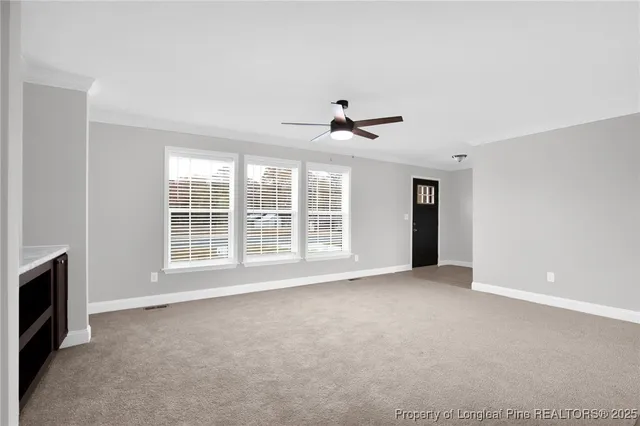 a view of an empty room with a fireplace and a window