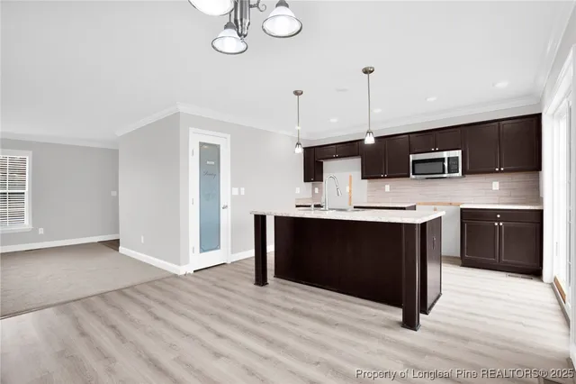 a kitchen with stainless steel appliances kitchen island sink refrigerator and cabinets
