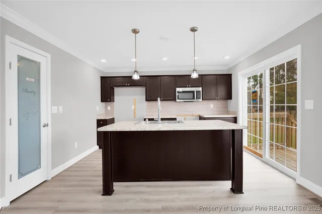a view of kitchen with stainless steel appliances granite countertop cabinets and wooden floor