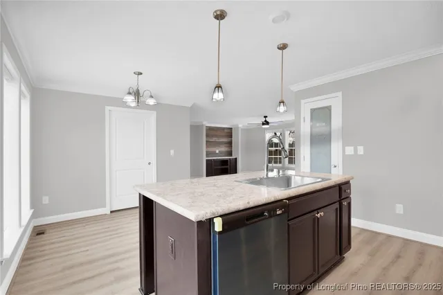 a kitchen with a sink a counter space and wooden floor