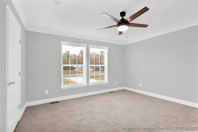 an empty room with ceiling fan and window