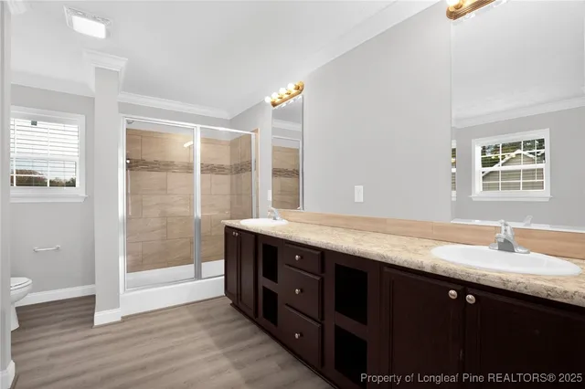 a bathroom with a granite countertop sink a mirror and a shower