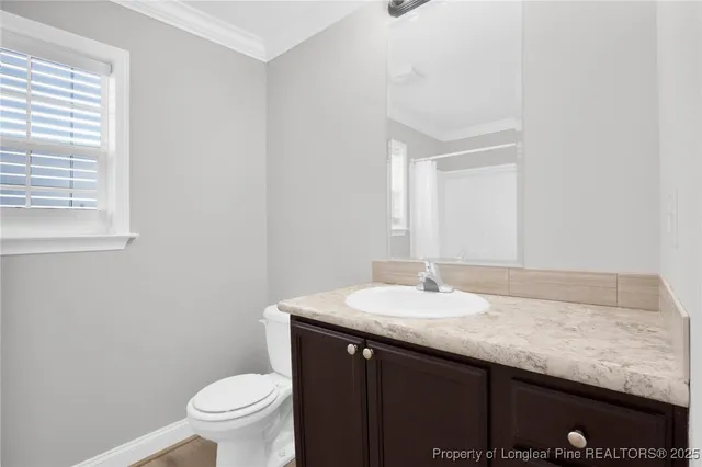 a bathroom with a granite countertop sink a toilet and a mirror