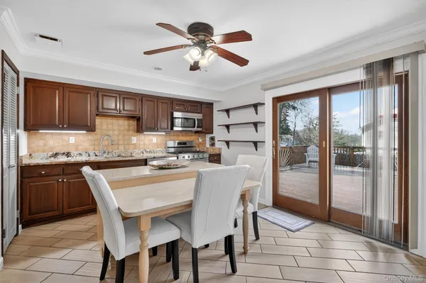 a kitchen with stainless steel appliances granite countertop a stove a refrigerator a sink a dining table and chairs