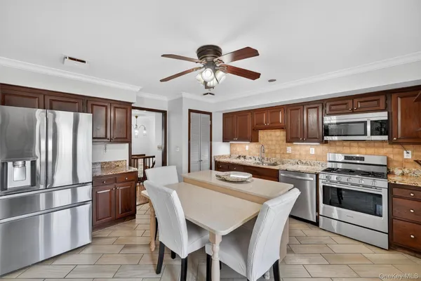 a kitchen with stainless steel appliances granite countertop a stove top oven a refrigerator a sink and a stove