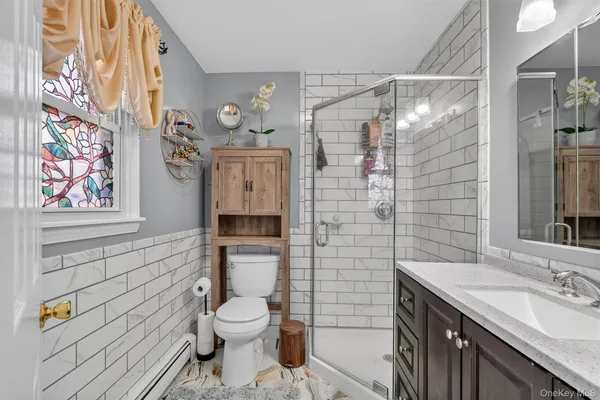 a bathroom with a granite countertop toilet sink and shower