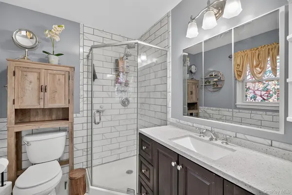 a bathroom with a sink a toilet and shower