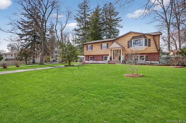 a view of a house with a big yard and large trees
