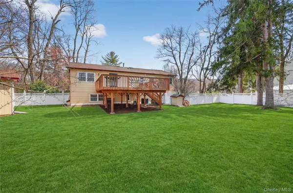a view of a house with a big yard and large trees