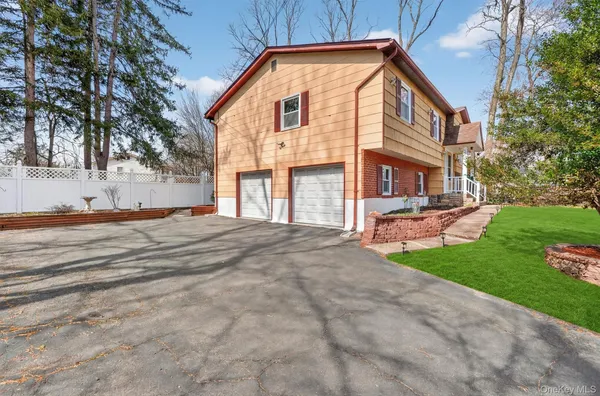 a front view of a house with yard and green space