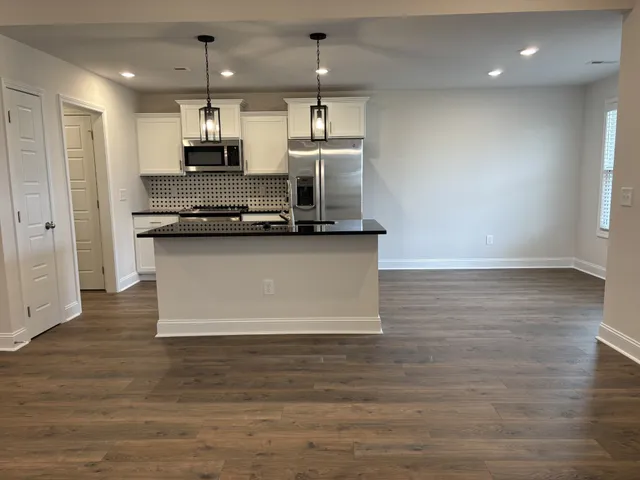 a kitchen with stainless steel appliances granite countertop a sink a stove top oven a counter space and cabinets