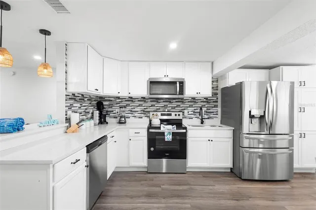 a kitchen with stainless steel appliances a refrigerator stove microwave and sink