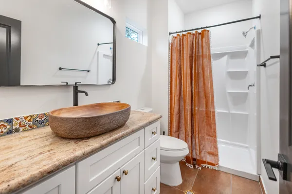 a bathroom with a granite countertop sink and a mirror