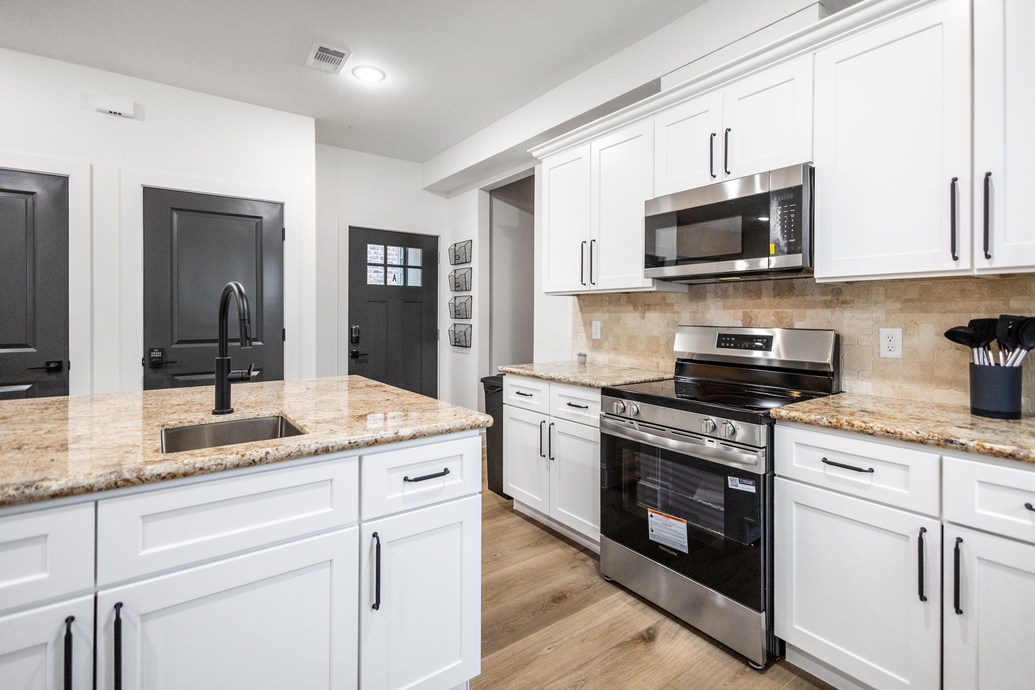 5015 Reed Road Houston, TX 77033 - Photo 7 of 13 a kitchen with stainless steel appliances granite countertop white cabinets a sink and dishwasher
