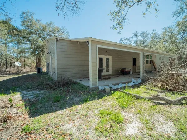 a view of a house with backyard and sitting area