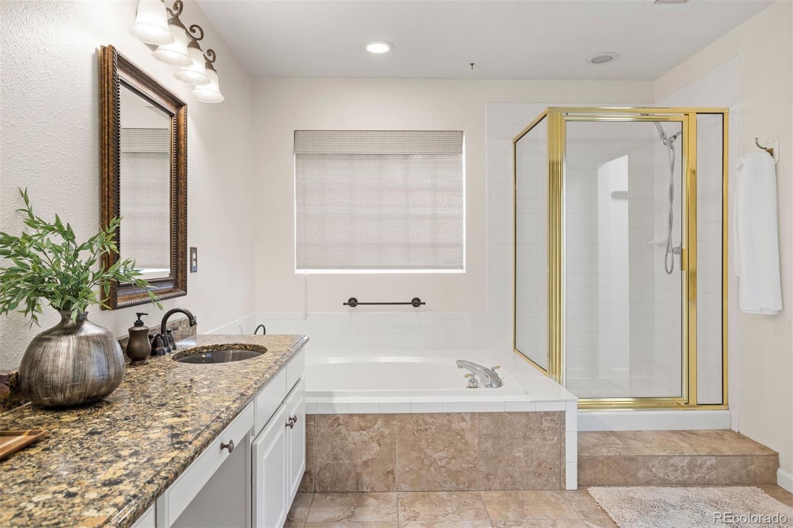 5426 East Knoll Place Highlands Ranch, CO 80130 - Photo 20 of 28 a bathroom with a granite countertop tub sink and mirror
