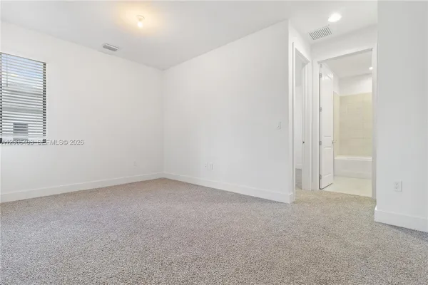 an empty room with a empty space and windows