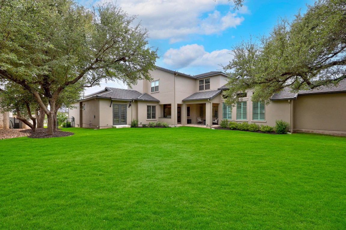 815 Flint Ridge Trail Georgetown, TX 78628 - Photo 31 of 39 a view of a white house next to a yard with big trees