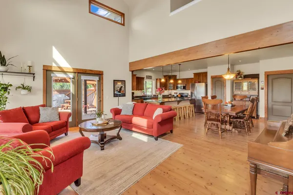 a living room with furniture a large window and wooden floor