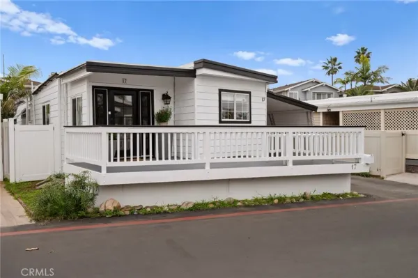 a view of a house with a wooden deck and a yard
