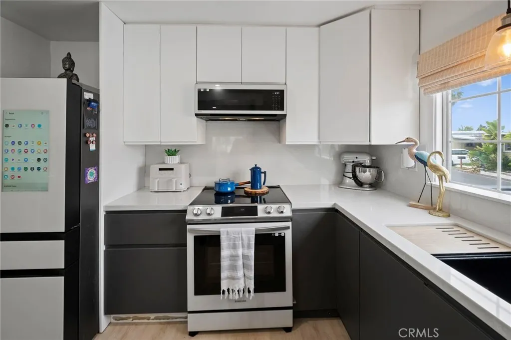 6550 Ponto, Unit 17 Carlsbad, CA 92011 - Photo 20 of 48 a kitchen with stainless steel appliances granite countertop a stove a sink and a refrigerator