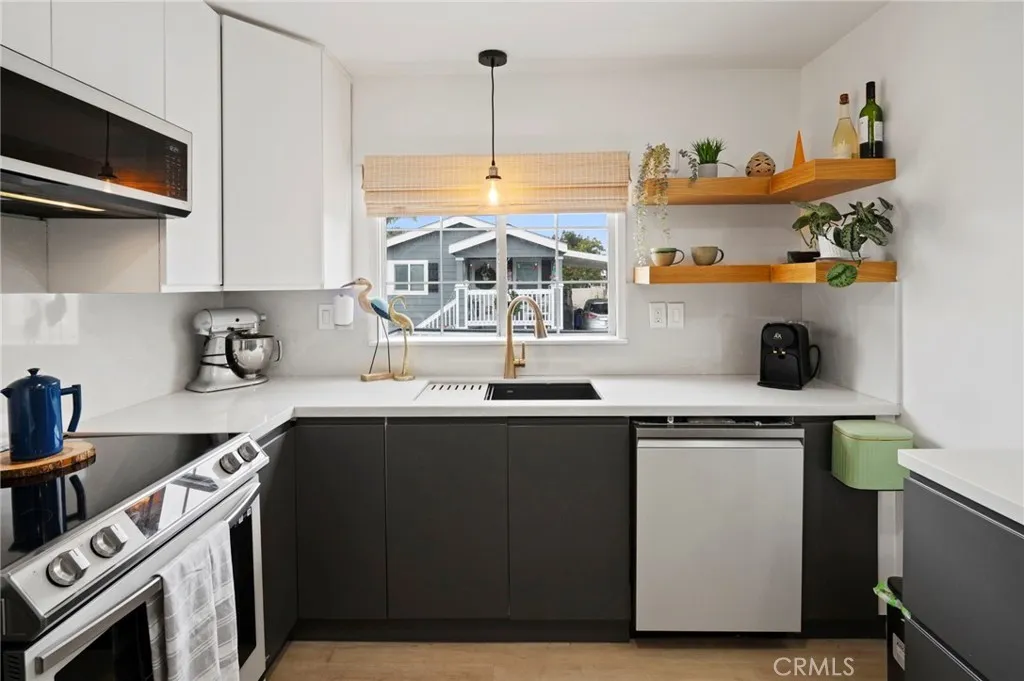 6550 Ponto, Unit 17 Carlsbad, CA 92011 - Photo 21 of 48 a kitchen with stainless steel appliances granite countertop a sink a stove and a microwave