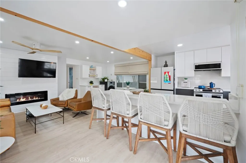 6550 Ponto, Unit 17 Carlsbad, CA 92011 - Photo 9 of 48 a living room with furniture a flat screen tv and kitchen view