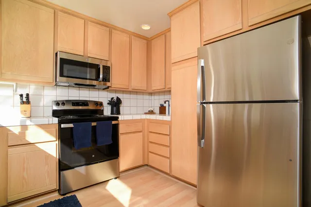 a kitchen with a refrigerator and a stove top oven