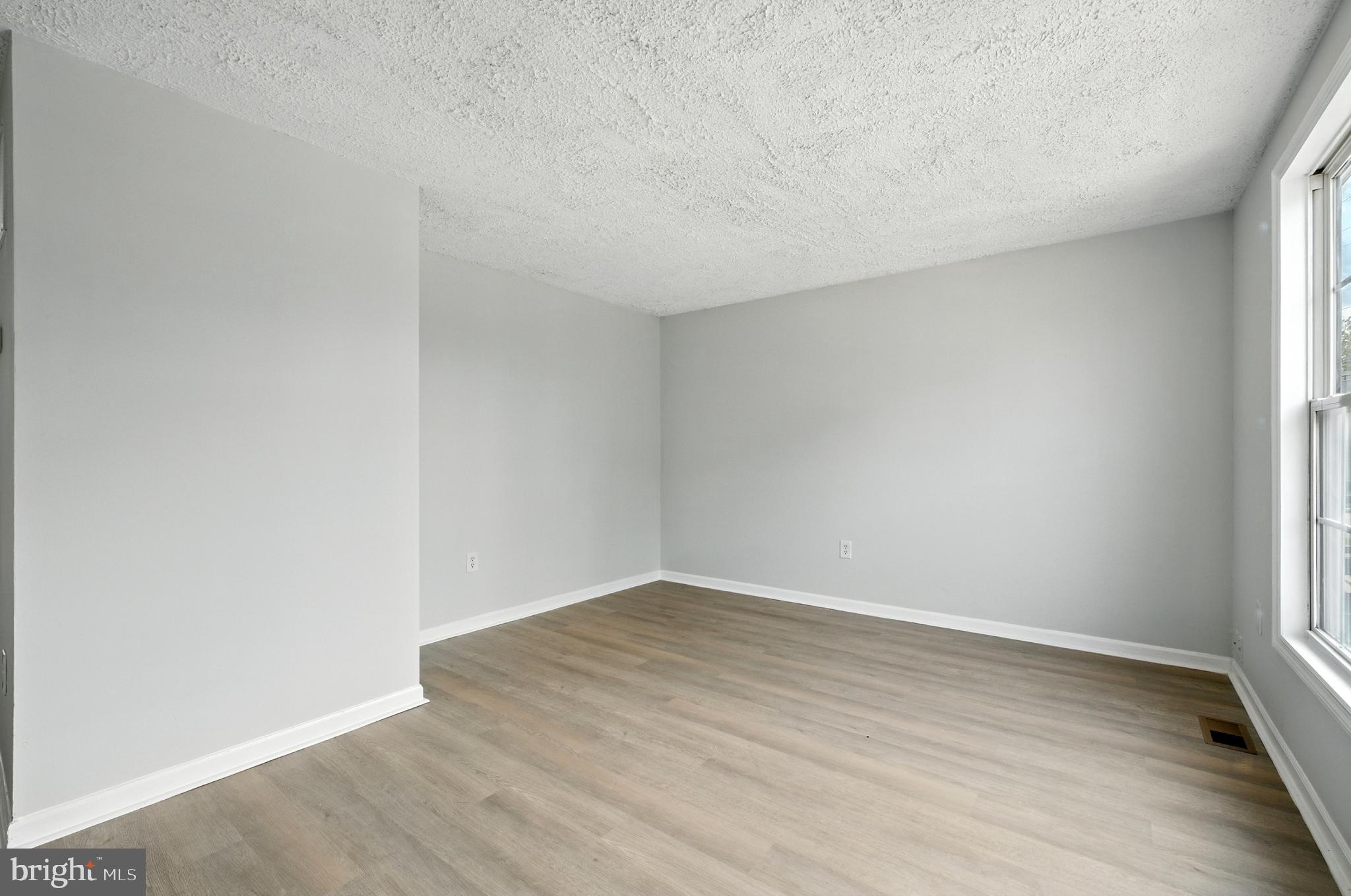 209 Magnolia Terrace Baltimore, MD 21221 - Photo 28 of 50 an empty room with wooden floor and windows