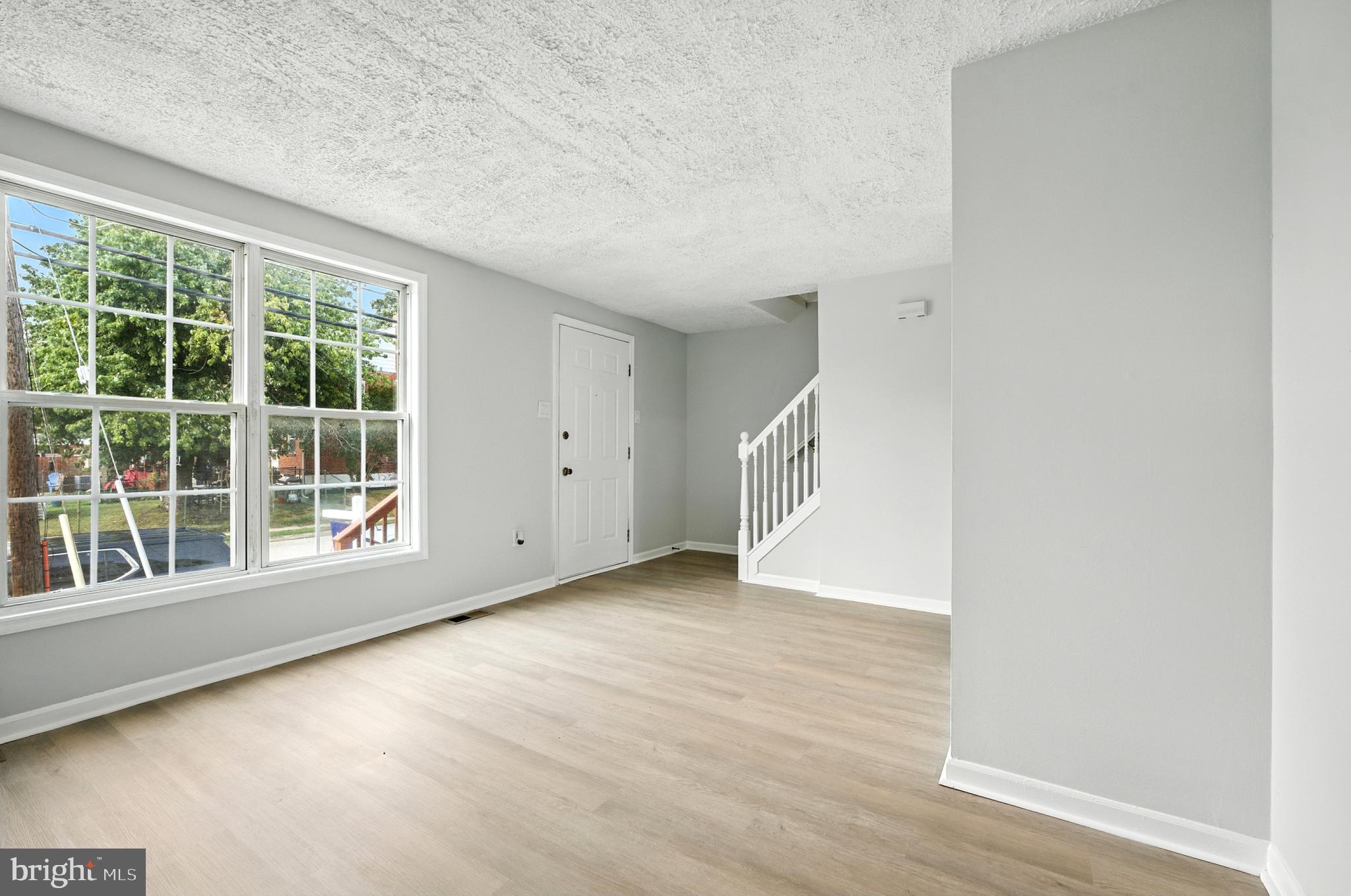 209 Magnolia Terrace Baltimore, MD 21221 - Photo 3 of 50 an empty room with wooden floor and windows