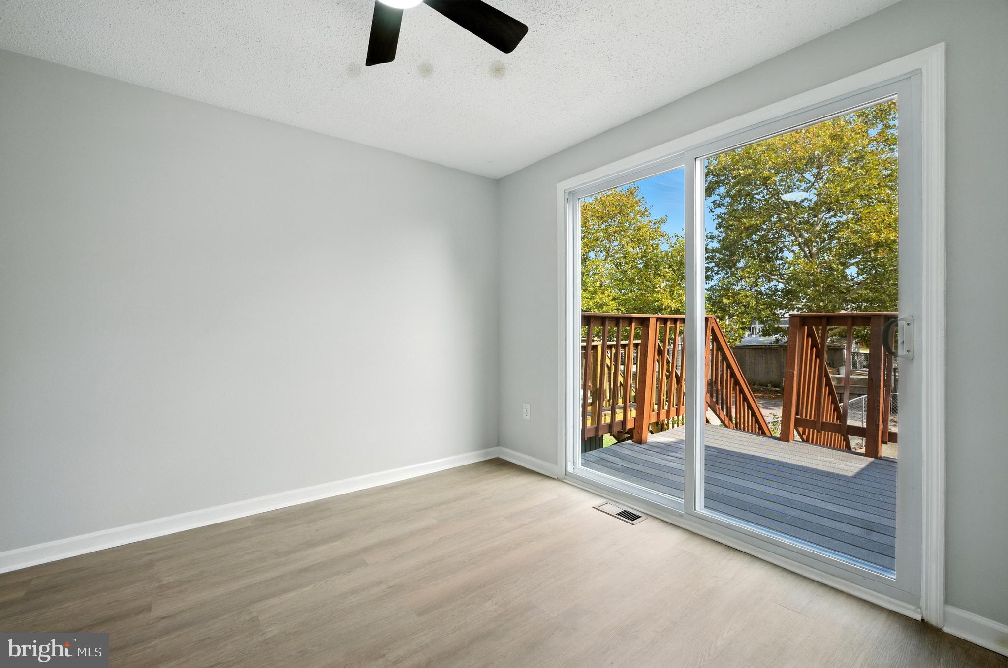 209 Magnolia Terrace Baltimore, MD 21221 - Photo 7 of 50 an empty room with wooden floor and windows