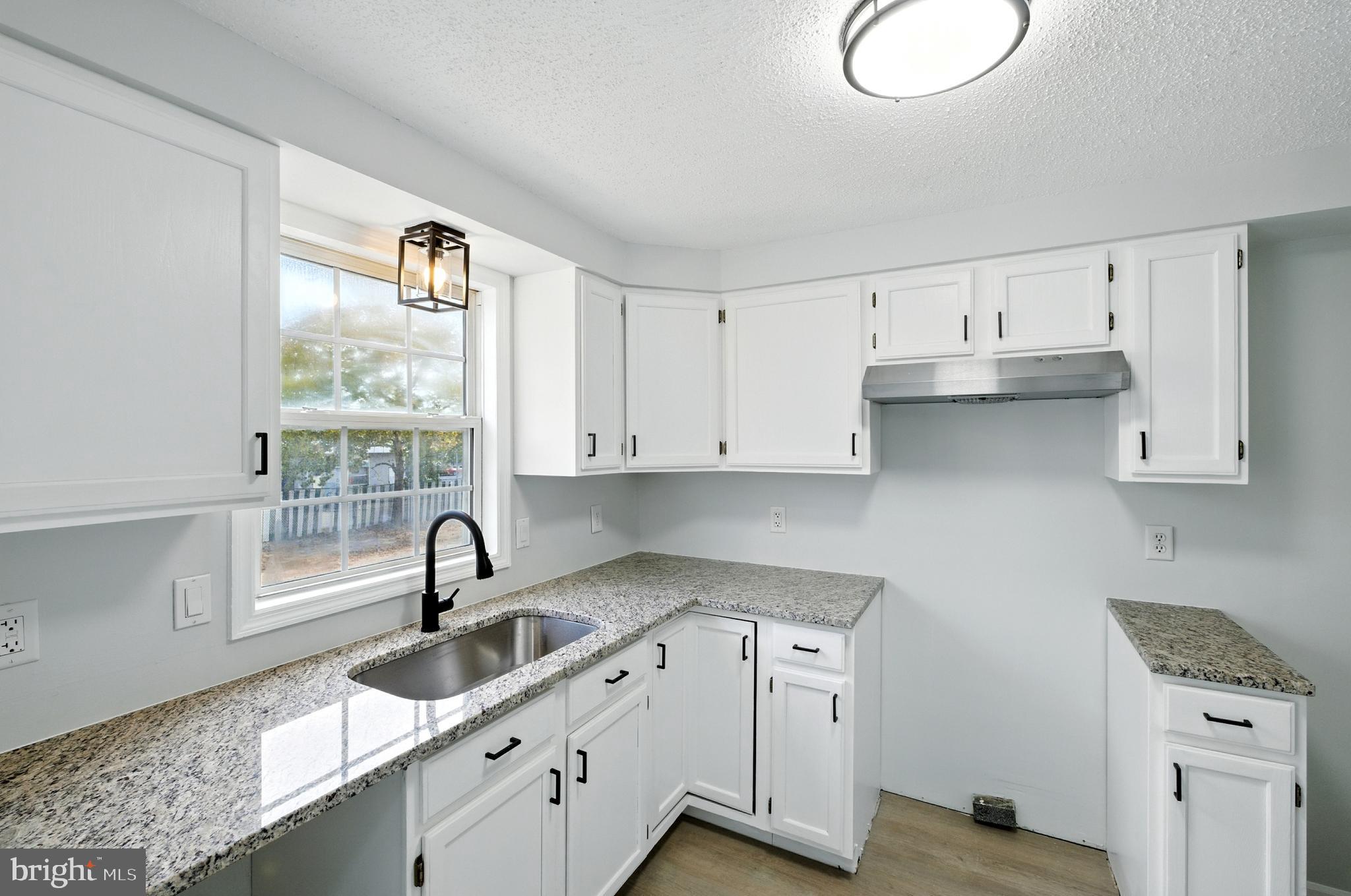 209 Magnolia Terrace Baltimore, MD 21221 - Photo 10 of 50 a kitchen with a sink cabinets and window