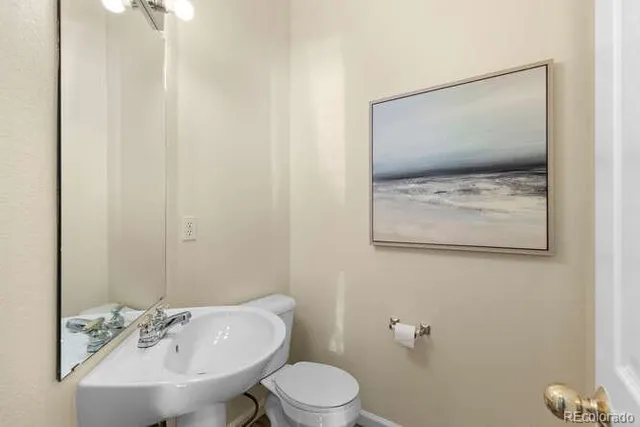 a bathroom with a toilet a sink and mirror