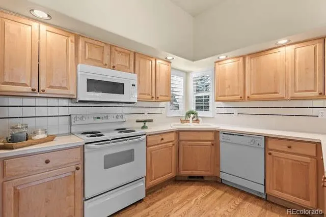 a kitchen with cabinets appliances a sink and a window