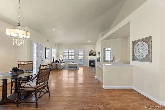 a view of a dining room and livingroom with furniture wooden floor a chandelier