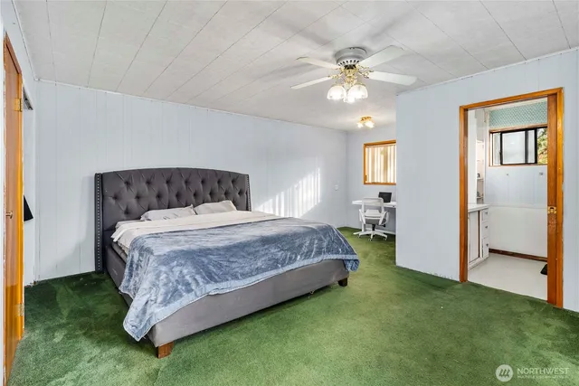 a bedroom with a bed and a mirror on dresser