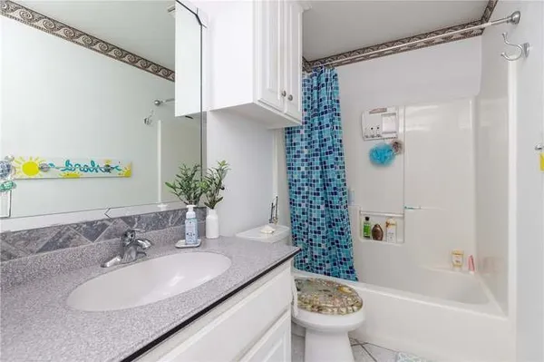 a bathroom with a granite countertop sink a toilet and shower