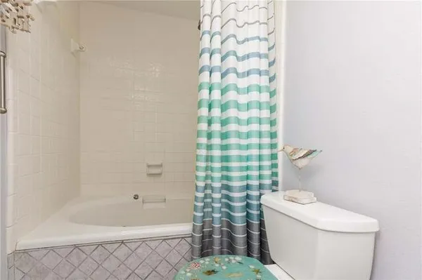 a white toilet sitting next to a bath tub