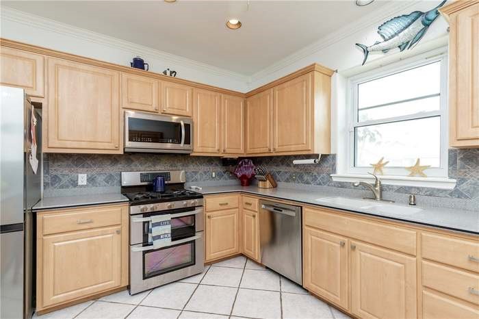 15833 Cuttysark Street Corpus Christi, TX 78418 - Photo 4 of 32 a kitchen with granite countertop white cabinets a sink and white appliances