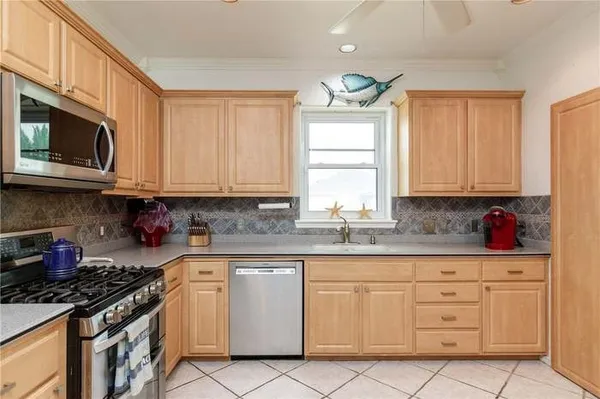 a kitchen with granite countertop white cabinets stainless steel appliances and a window