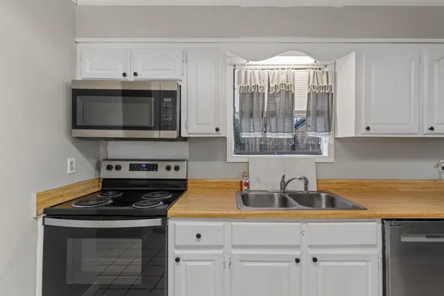 a kitchen with appliances a sink and cabinets