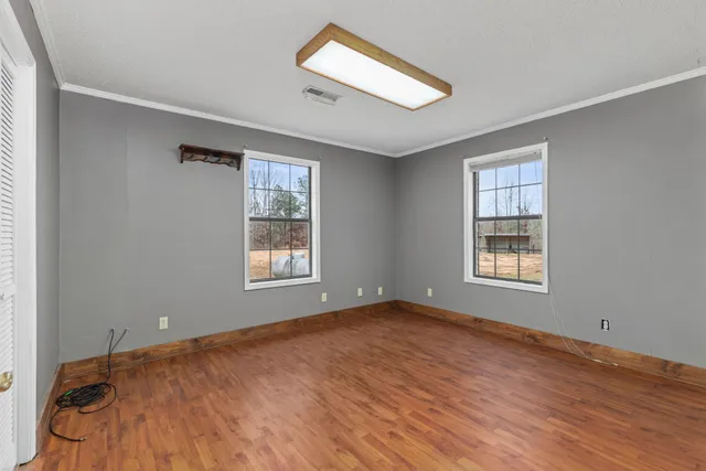 a big room with wooden floor and a window