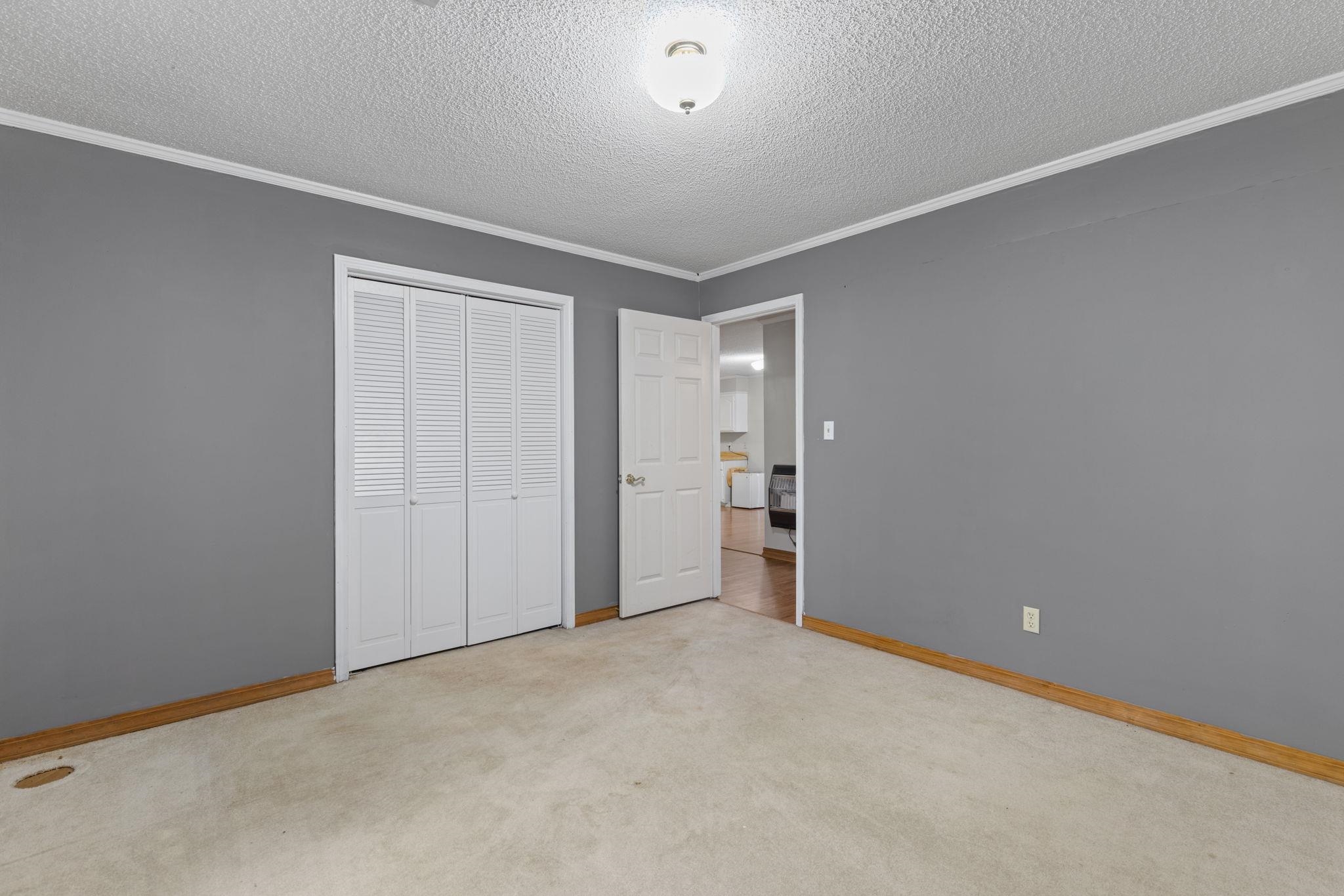 310 County Road 638 Corinth, MS 38834 - Photo 33 of 40 Unfurnished bedroom with crown molding, light carpet, a closet, and a textured ceiling