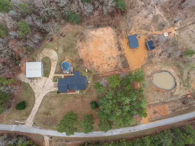 an aerial view of a house with outdoor space and tennis court