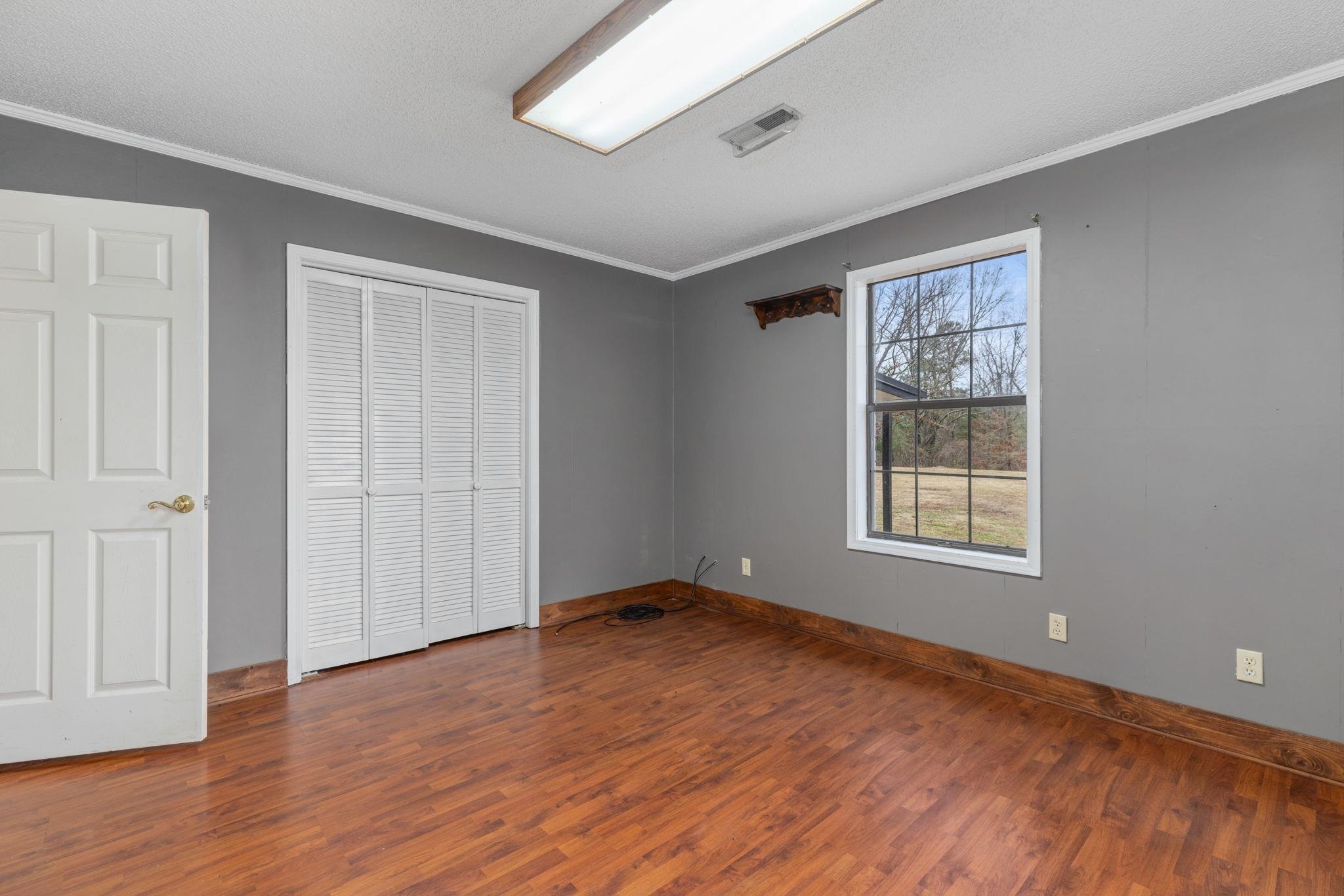 310 County Road 638 Corinth, MS 38834 - Photo 35 of 40 Unfurnished bedroom with ornamental molding, dark wood-style floors, a closet, and a textured ceiling