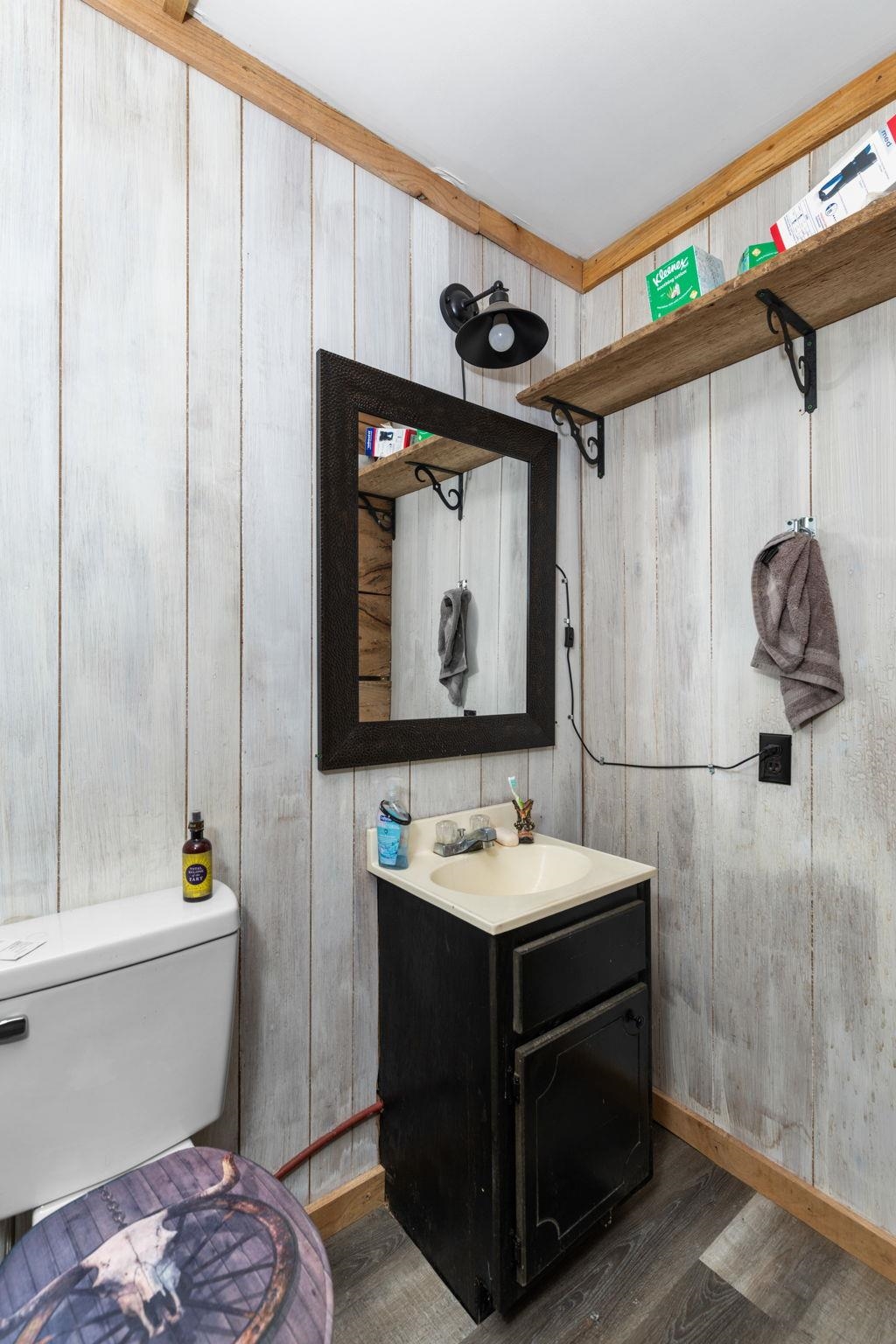 310 County Road 638 Corinth, MS 38834 - Photo 4 of 40 Half bathroom with vanity, dark wood-type flooring, and wooden walls