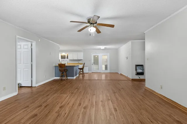 a view of a livingroom with wooden floor and a ceiling fan