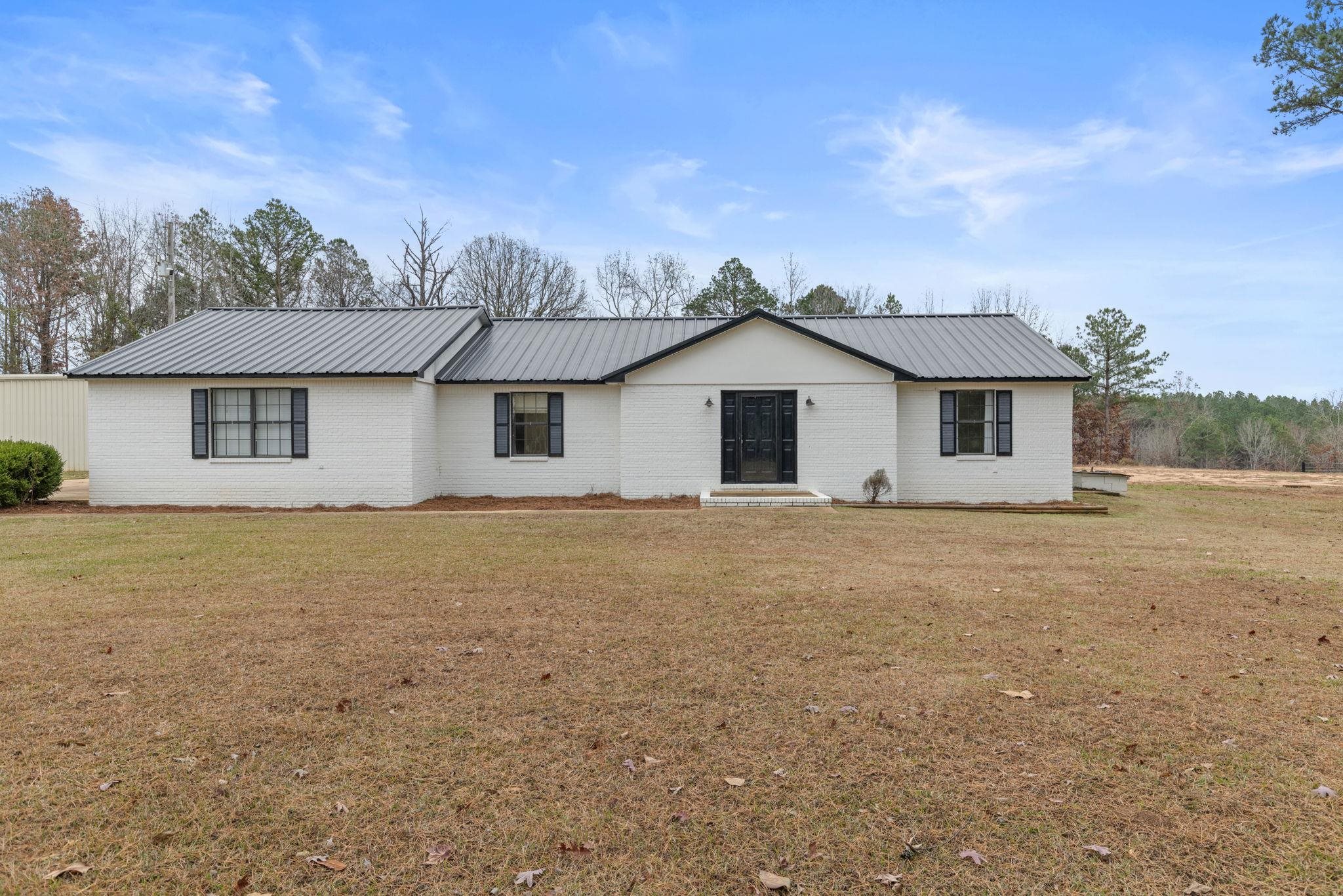 310 County Road 638 Corinth, MS 38834 - Photo 6 of 40 View of front of home with a metal roof, a front yard, and brick siding