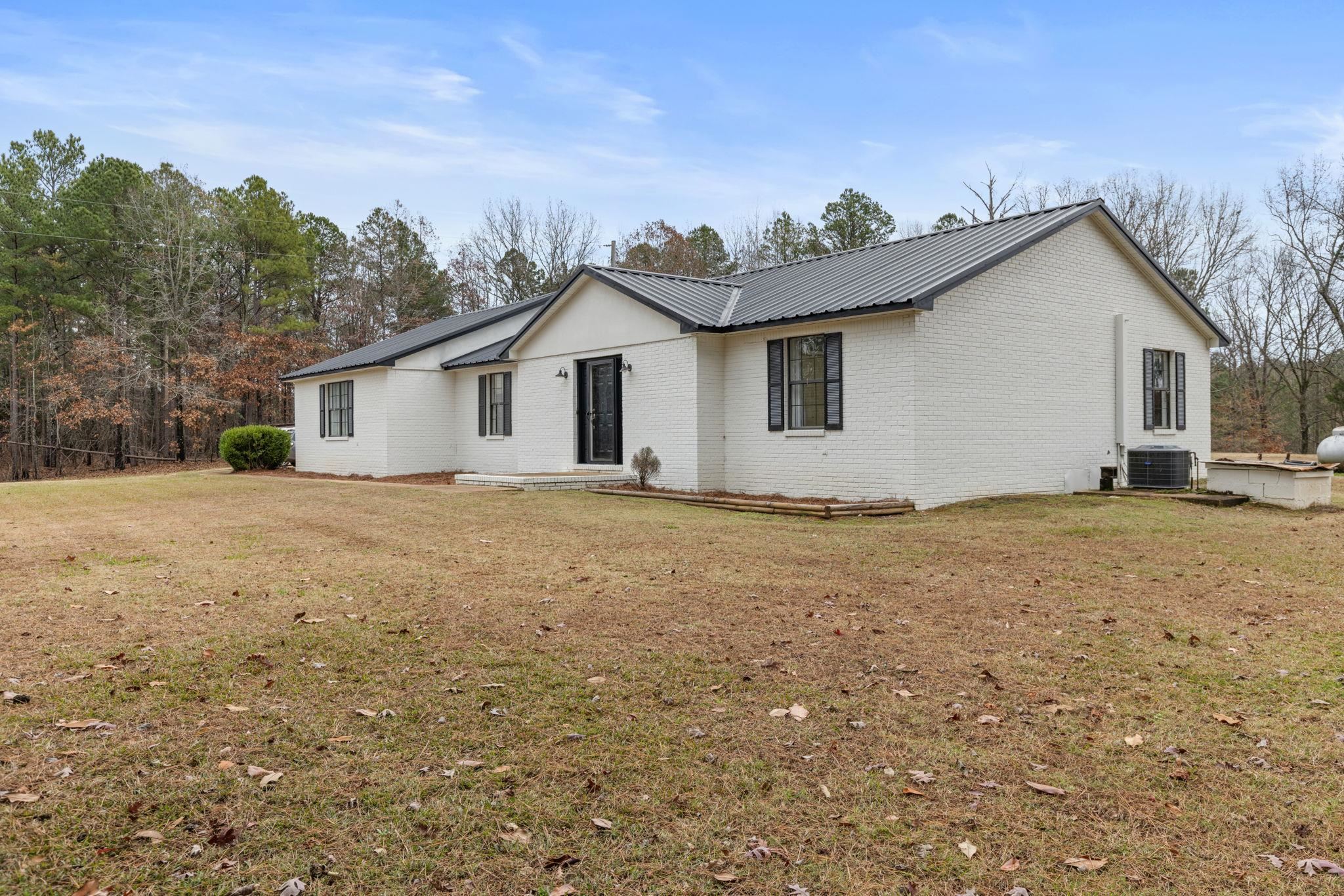 310 County Road 638 Corinth, MS 38834 - Photo 7 of 40 View of front facade featuring a metal roof, brick siding, and a front lawn